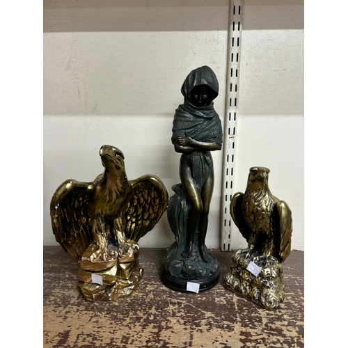 321A - A pair of resin gilt eagle figures and a figure of a hooded female