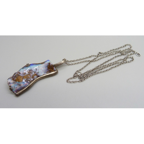 1009 - A silver mounted large rough opal studio pendant on a silver chain, opal 45mm