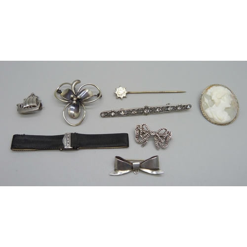 1032 - Six silver brooches, stick pin and a silver mounted ribbon bracelet