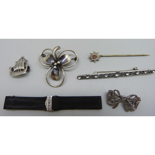 1032 - Six silver brooches, stick pin and a silver mounted ribbon bracelet