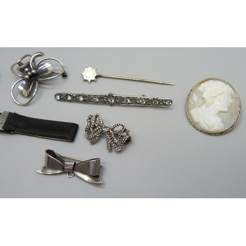 1032 - Six silver brooches, stick pin and a silver mounted ribbon bracelet