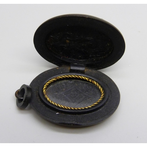 1038 - A carved jet locket and a costume brooch