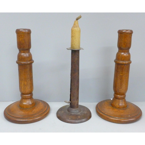 687 - A pair of turned oak candlesticks and single metal candlestick