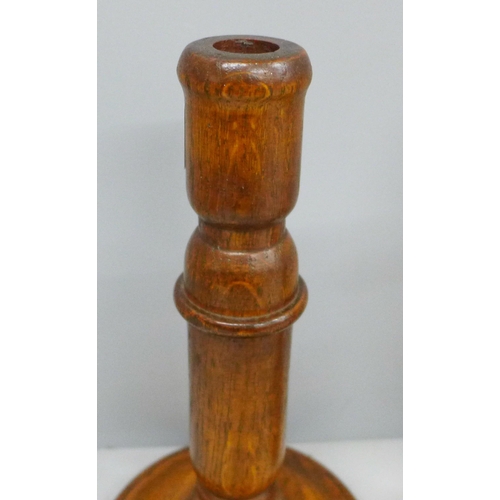 687 - A pair of turned oak candlesticks and single metal candlestick