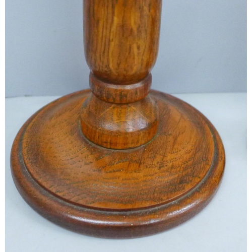 687 - A pair of turned oak candlesticks and single metal candlestick