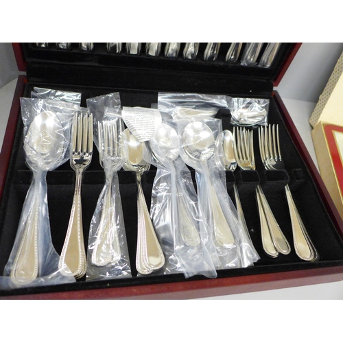 692 - A George Butler canteen of stainless steel cutlery and six horse racing place mats, boxed