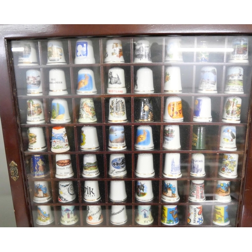 1077 - A large collection of thimbles displayed in three small cabinets with  a collection of bone china an... 