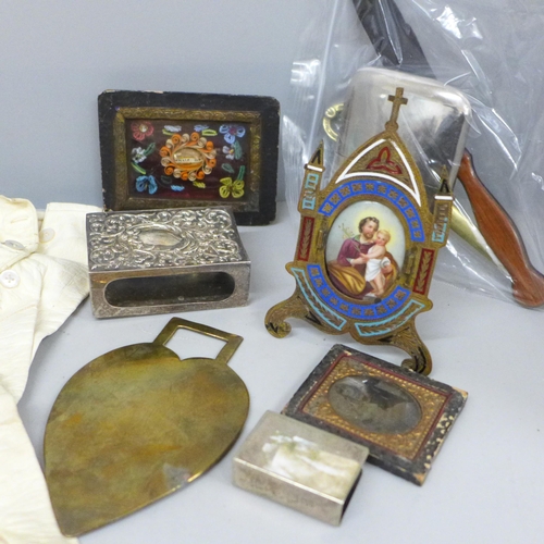 709 - A brass and enamel easel with devotional plaque, small framed Holy relic, 5 Franc coin brooch, a/f a... 