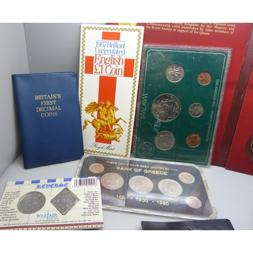 846 - A collection of coin packs including 1987 uncirculated English £1 coin, a medallion, Imperial War Mu... 