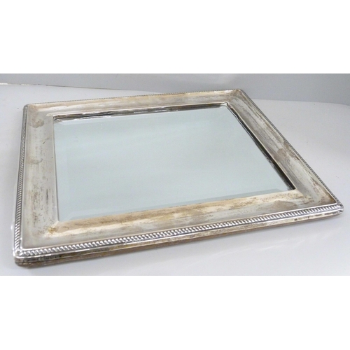 861 - A silver framed mirror with bevelled edge, with oak back, back stand requires repair, height 33.5cm