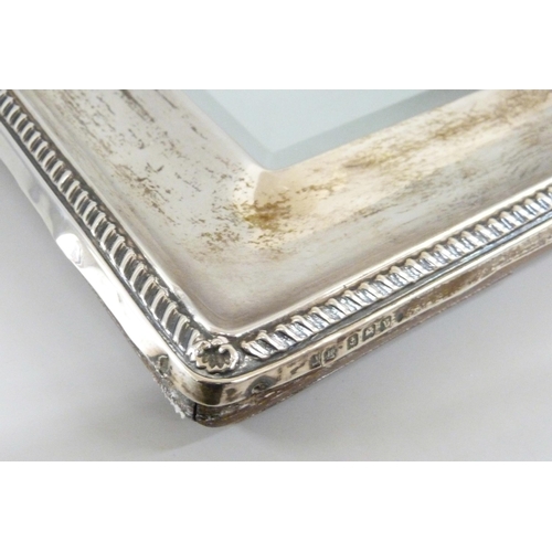 861 - A silver framed mirror with bevelled edge, with oak back, back stand requires repair, height 33.5cm