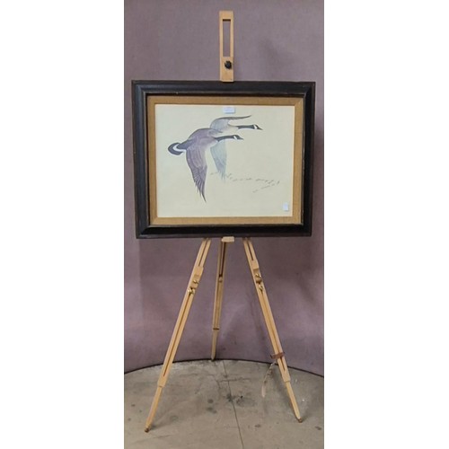 318 - A Charles E. Murphy print of Canada geese flying in formation, framed and a beech artists easel