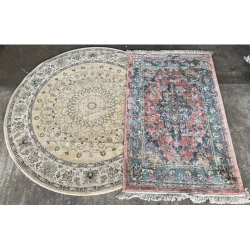 166 - A cream circular rug and a terracotta ground runner (160cm perimeter) (150cm x 91cm)