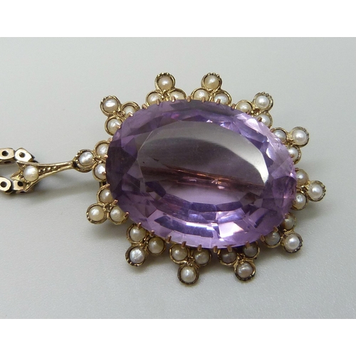 7014 - A yellow metal amethyst set pendant with a seed pearl border, on a 9ct gold chain, 15g total, pendan... 