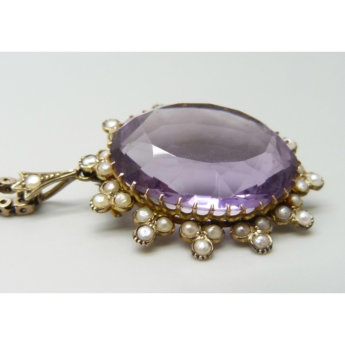 7014 - A yellow metal amethyst set pendant with a seed pearl border, on a 9ct gold chain, 15g total, pendan... 