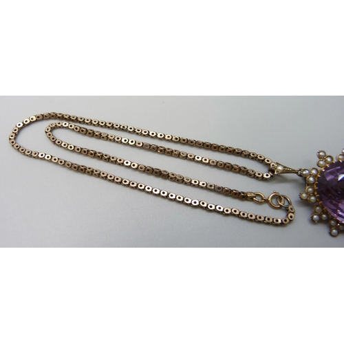 7014 - A yellow metal amethyst set pendant with a seed pearl border, on a 9ct gold chain, 15g total, pendan... 