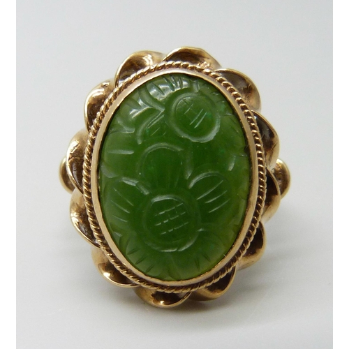 7015 - A 9ct gold oval carved jade ring, London 1960, stone 1.7 x 1.3cm, 7.5g, U