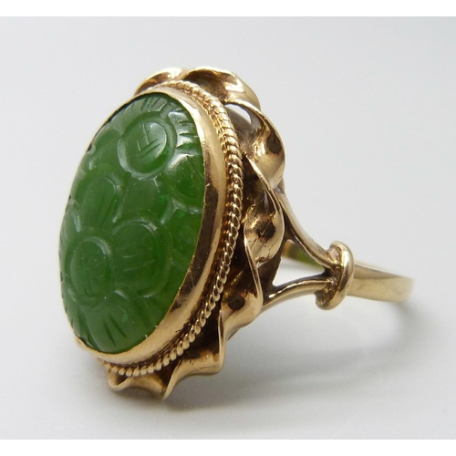 7015 - A 9ct gold oval carved jade ring, London 1960, stone 1.7 x 1.3cm, 7.5g, U