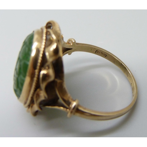 7015 - A 9ct gold oval carved jade ring, London 1960, stone 1.7 x 1.3cm, 7.5g, U