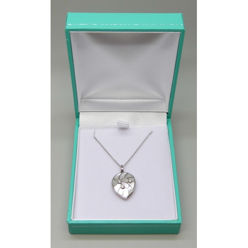 7021 - An 18ct white gold diamond and mother of pearl pendant on an 18ct white gold 18 inch chain, 0.03ct, ... 