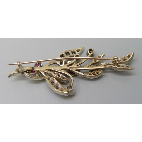 7026 - A white metal brooch with yellow metal finish verso, set with diamonds, sapphires, rubies and pearls... 