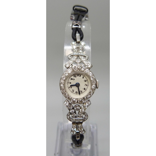 7050 - A lady's platinum and diamond set cocktail wristwatch, 19mm case including crown, one baguette cut d... 