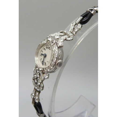 7050 - A lady's platinum and diamond set cocktail wristwatch, 19mm case including crown, one baguette cut d... 