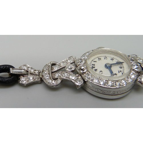 7050 - A lady's platinum and diamond set cocktail wristwatch, 19mm case including crown, one baguette cut d... 