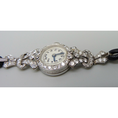 7050 - A lady's platinum and diamond set cocktail wristwatch, 19mm case including crown, one baguette cut d... 