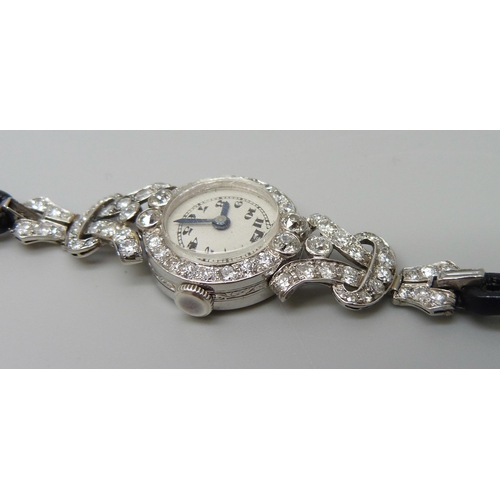 7050 - A lady's platinum and diamond set cocktail wristwatch, 19mm case including crown, one baguette cut d... 