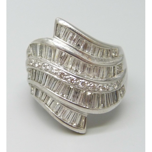 7053 - A large white metal ring set with approximately 4cts of baguette cut diamonds, 2.5cm, 22.4g, V/W