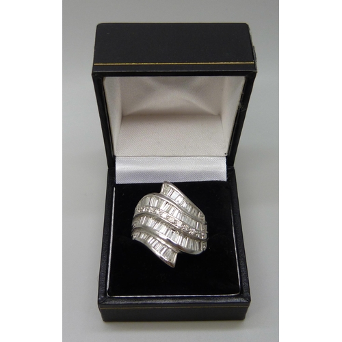 7053 - A large white metal ring set with approximately 4cts of baguette cut diamonds, 2.5cm, 22.4g, V/W