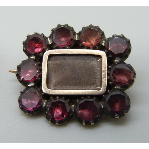 7060 - Two 19th Century yellow metal mourning brooches set with garnets, 3.9g, 2.4 x 1.8cm and 1.8g, 1.6 x ... 