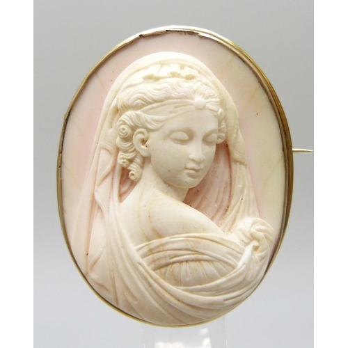 7064 - A yellow metal framed angel skin cameo brooch depicting a lady in a veil, tests as 14ct gold with a ... 