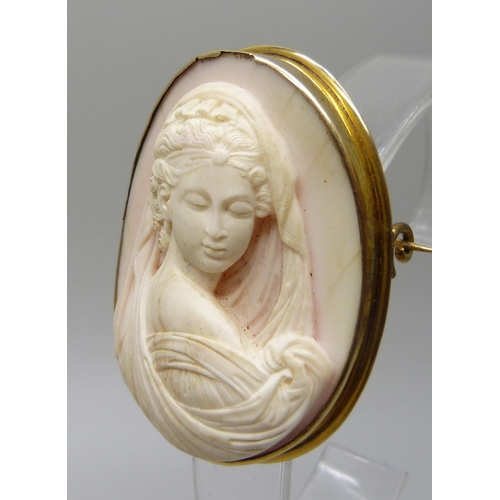 7064 - A yellow metal framed angel skin cameo brooch depicting a lady in a veil, tests as 14ct gold with a ... 