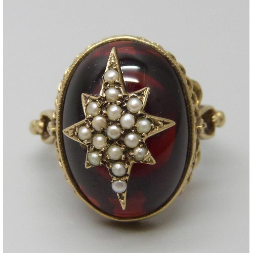 7068 - A Victorian style 9ct gold ring with seed pearl set starburst detail on a cabochon garnet, London 19... 