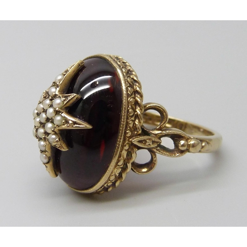 7068 - A Victorian style 9ct gold ring with seed pearl set starburst detail on a cabochon garnet, London 19... 