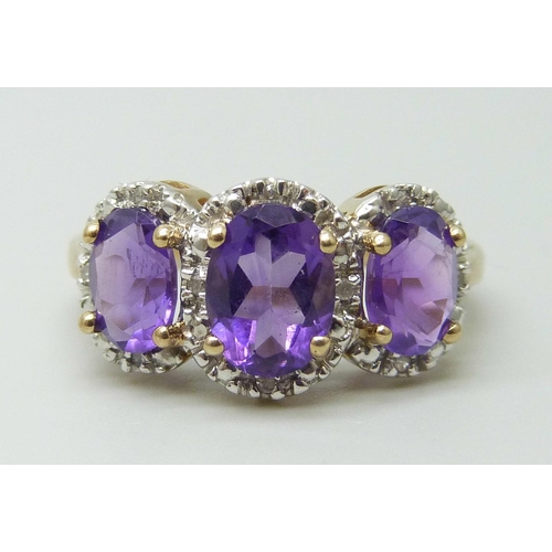 7085 - A 9ct gold three stone amethyst and diamond ring 3.4g, P