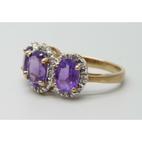 7085 - A 9ct gold three stone amethyst and diamond ring 3.4g, P