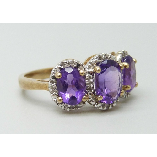 7085 - A 9ct gold three stone amethyst and diamond ring 3.4g, P