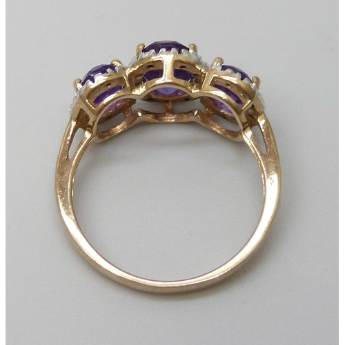 7085 - A 9ct gold three stone amethyst and diamond ring 3.4g, P