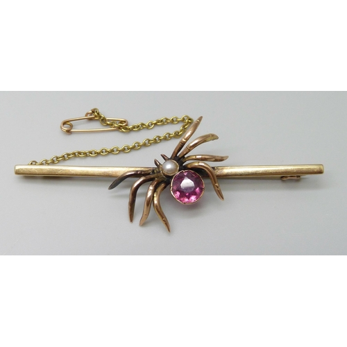 7086 - A 9ct gold spider bar brooch set with a seed pearl and pink stone, 4.9g, 6.4cm