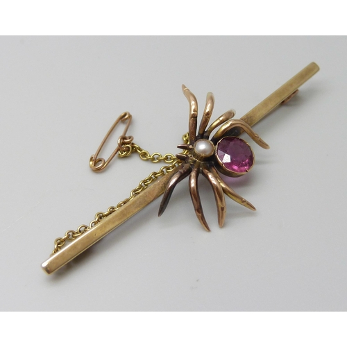 7086 - A 9ct gold spider bar brooch set with a seed pearl and pink stone, 4.9g, 6.4cm