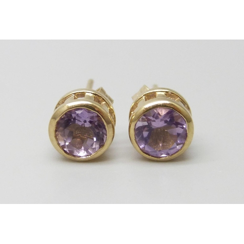 7087 - A pair of yellow metal amethyst stud earrings, the butterflies marked 9ct, 1.1g