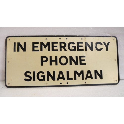 9034 - A modern-era  metal warning sign inscribed IN EMERGENCY PHONE SIGNALMAN. Measures 30 x 68cm HxW. To ... 