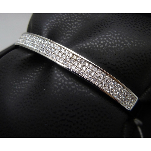 7132 - A silver bangle set with three rows of cubic Zirconia, 16.6g, band 0.6cm wide