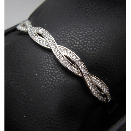 7133 - A silver twist bangle set with cubic Zirconia, 18.8g, band 0.7cm wide