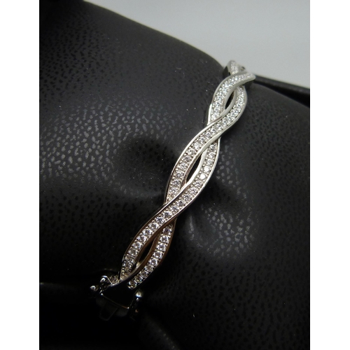 7133 - A silver twist bangle set with cubic Zirconia, 18.8g, band 0.7cm wide