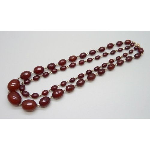 7146 - A two row sherry amber necklace, 54g, largest bead 2.2 x 1.6cm