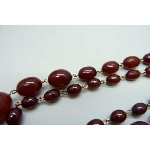 7146 - A two row sherry amber necklace, 54g, largest bead 2.2 x 1.6cm